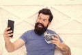 Good morning. Special gift. Bearded man using mobile technology in bed. Handsome guy taking selfie with gift box. Happy Royalty Free Stock Photo