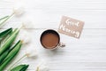 Good morning text sign on greeting card at tulips with coffee on Royalty Free Stock Photo