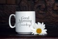 Good morning Tuesday. A Tuesday coffee concept with a white cup of coffee or tea and a daisy flower decoration on the table Royalty Free Stock Photo