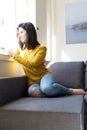 Good morning! Wanna pass by? Woman relaxing on couch and making a phone call Royalty Free Stock Photo