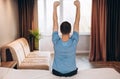 Good morning Young man waking up in bed and stretching his arms, back view, copy space Royalty Free Stock Photo