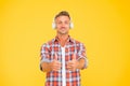 Good music is just a pair of headphones away. Happy man show thumbs ups listening to music yellow background. New Royalty Free Stock Photo