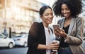Good news just came in from the office for us. Shot of two businesswomen looking at something on a cellphone in the city Royalty Free Stock Photo