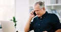 Good news put a smile on everyones face. a cheerful mature businessman answering a phone call in his office. Royalty Free Stock Photo