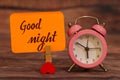 Good Night text attached with heart clip and alarm clock. Royalty Free Stock Photo