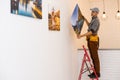 Good place for picture. Cheerful young men hanging a picture on the wall