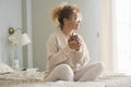 Good positive wake up morning adult woman sitting on the bed and drink smiling at the window light. Female people healthy Royalty Free Stock Photo