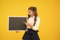 A good publicity for our school. Small kid pointing finger at blank blackboard with school publicity. Little child Royalty Free Stock Photo