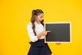 A good publicity for our school. Small kid pointing finger at blank blackboard with school publicity. Little child Royalty Free Stock Photo