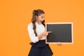 A good publicity for our school. Small kid pointing finger at blank blackboard with school publicity. Little child Royalty Free Stock Photo