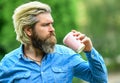 Good start of the morning. man with a cup of coffee outdoors. Handsome calm bearded man outdoors with a cup of coffee