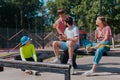 In a good sunny day, group of friends very attractive, multiethnic enjoying the time in a modern, skate park they