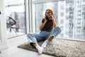 Good talk with boyfriend. Attractive woman talking on mobile phone and smiling while sitting on the carpet at home Royalty Free Stock Photo