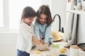 Good teamwork. Preschool friends learning how to cook with flour in the white kitchen