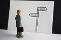 Good versus bad way. Miniature man looks on handdrawn guidepost and decides about future. Good, evil, business fair access topic