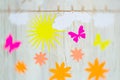 Good weather, bright sunny day concept. Clouds, sun, flowers and paper butterflies are attached with clothespins Royalty Free Stock Photo