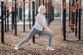 Glad aged woman exercising outdoors