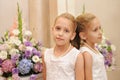 A good young blonde girl in a beautiful white dress standing near the mirror and resting. The girl is beautiful but has tired face Royalty Free Stock Photo