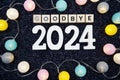 Goodbye 2024 alphabet letter decorate with LED cotton ball on blue knitted fabric background