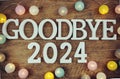 Goodbye 2024 alphabet letters and LED cotton ball decoration on wooden background