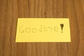Goodbye handwrite on a yellow paper with a pen on a table