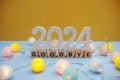 Goodbye 2024 letters with LED cotton balls decoration on blue background