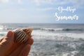 Goodbye Summer greeting card with hand holding sea shell on a blue ocean water background.