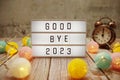 Goodbye 2023 text on lightbox on wooden background