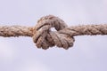 Tied knot on a white rope isolated on white background. Macro photo Royalty Free Stock Photo