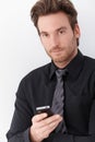 Goodlooking businessman holding mobile phone