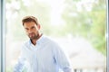 Goodlooking man in shirt standing against the window