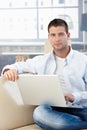 Goodlooking man working at home on laptop