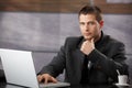 Goodlooking manager sitting at desk in office Royalty Free Stock Photo