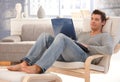 Goodlooking young man relaxing at home with laptop Royalty Free Stock Photo