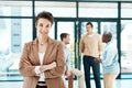 Goodness and hard work are rewarded with respect. Portrait of a designer standing with her arms crossed with colleagues Royalty Free Stock Photo