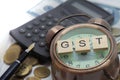 Goods and Services Tax word on Alarm clock and stacks coins