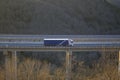 Goods truck crossing a highway bridge at sunset horizontal