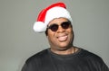 Goofy African American man wearing a Santa Claus hat against a solid background Royalty Free Stock Photo