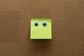 Googly eyes on green clean  sticky note on cork board concept using sticky notes Royalty Free Stock Photo