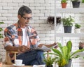 A goold looking senior Asian man wearing eyesglasses sitting and drink coffee and reading the newspaper with happiness. Idea for