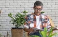 A goold looking senior Asian man wearing eyesglasses sitting and drink coffee and reading the newspaper with happiness. Idea for