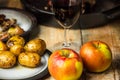 Rustic, romantic dinner - goose baked with apples and potatoes, next to a glass of red wine on a wooden background, rustic table