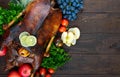 Goose baked in the oven with apples and grapes. Christmas goose on a wooden background