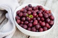 gooseberries in big bowl on wooden table. Ceramic bowl full of ripe tasty berries