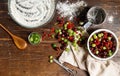 Gooseberries and red currants on a wooden table, a bowl of flour, a wooden spoon and a linen towel. Top view Royalty Free Stock Photo