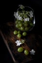 Gooseberry and flowers in glass cup on a wooden Board, still life with berries Royalty Free Stock Photo