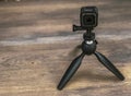 GoPro 5 Camera on a mini tripod pointed on a wooden table. Royalty Free Stock Photo