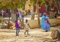 Goree island, Senegal- April 22 2019: Unidentified girls and woman in typical colorful Senegalese dress walk along a sandy street