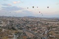 Goreme, Cappadocia, Turkey - August 16, 2017: Beautiful view of the village of Goreme with balloons flying over it at sunrise.