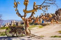 Goreme National Park, Cappadocia, Turkey. Old wooden cart stands under tree with clay pots hanging from its branches. Unusual